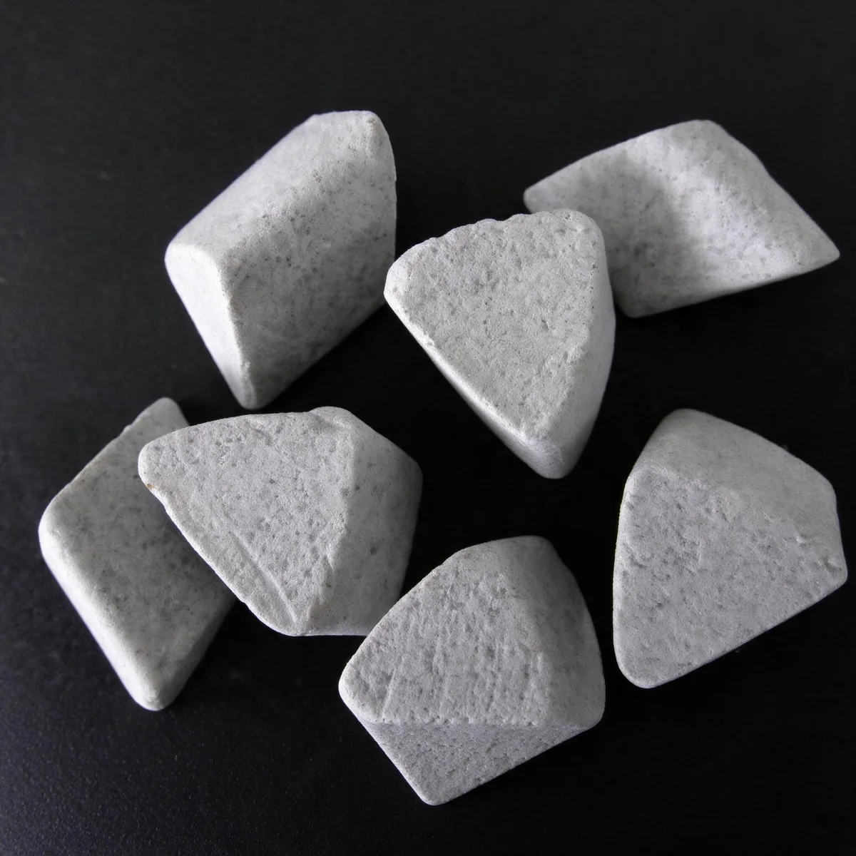 Close-up of triangular and conical ceramic polishing media